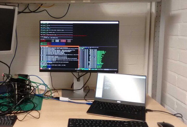 A 2016 workbench: an Ansible play recap on the monitor, a stack of Raspberry Pis wired up beside it.